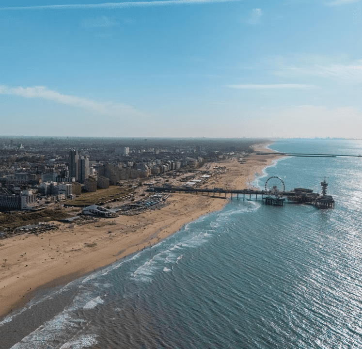 Luchtfoto van het strand en de pier van Scheveningen bij Hotel Four Stories