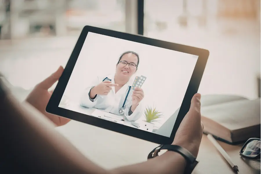 Patient receiving a medication explanation through AI medical assistant software during a tablet-based video appointment.