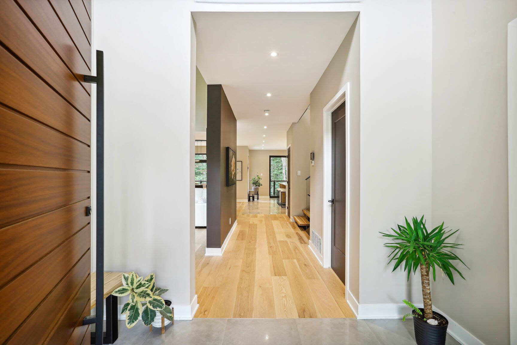 Hall d'entrée ouvert sur l'aire de vie et la terrasse arrière.