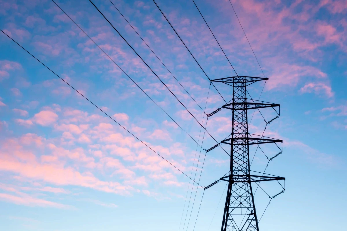 Power lines in front of clouds at sunset/sunrise.