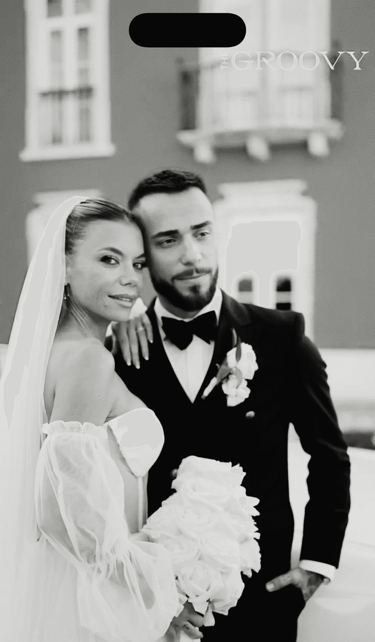 a newly married couple walking through a field
