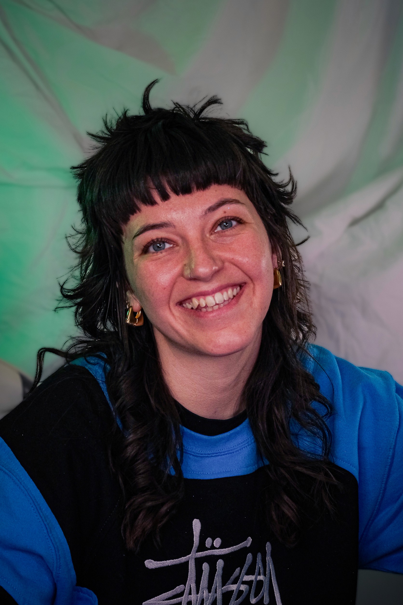 a photo of lauren the owner of campaign cult she has choppy brown hair and a big smile wearing a blue jumper