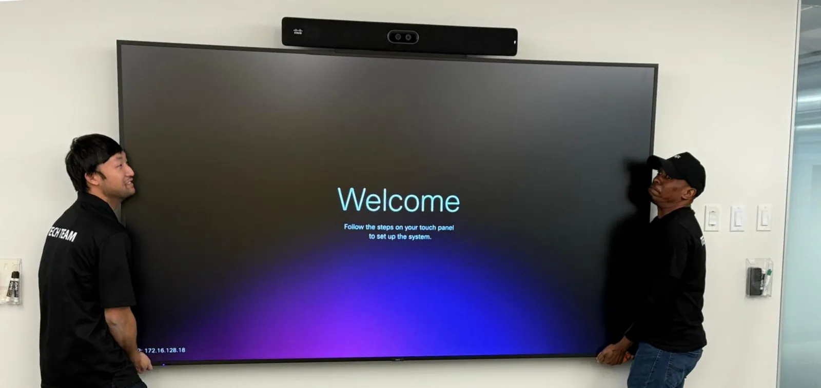 Professional installation of large-format display and video conferencing system in a corporate office.