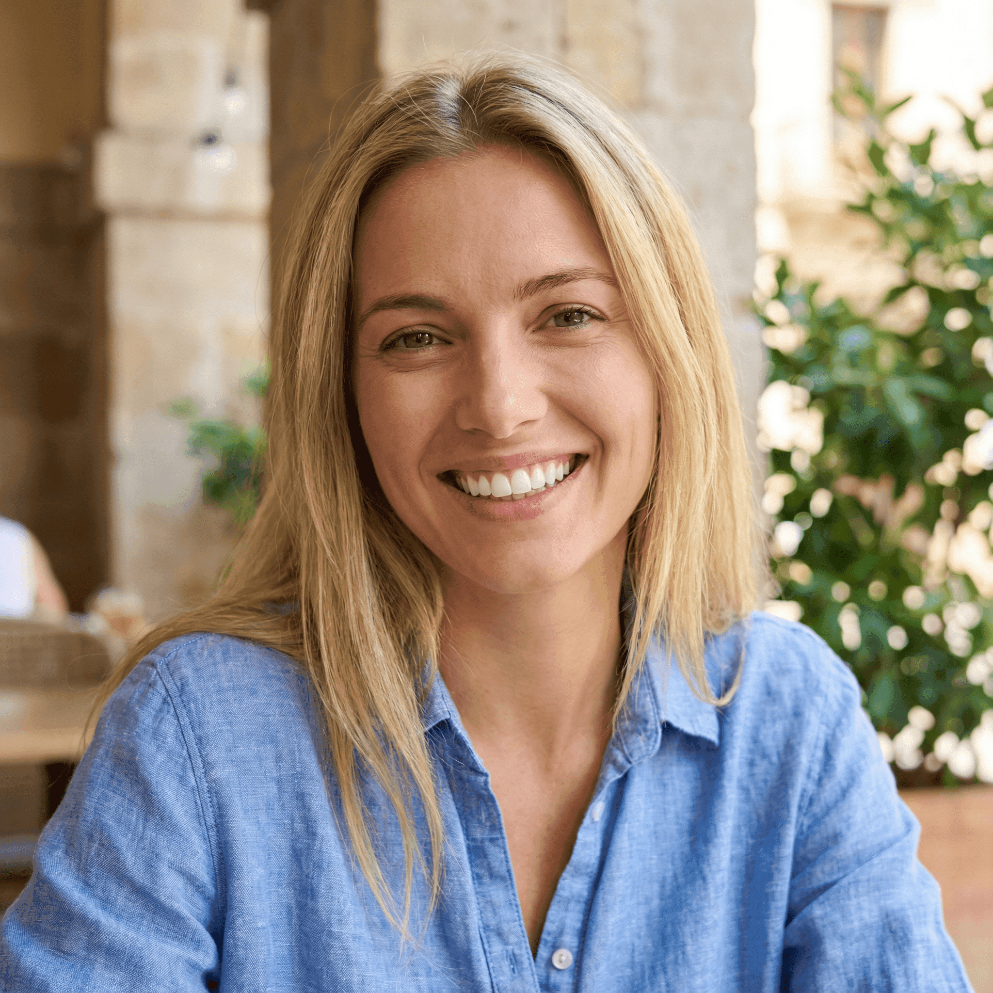 Invisalign in Dubai with a woman smiling confidently, holding her clear aligners, highlighting discreet and effective treatment.