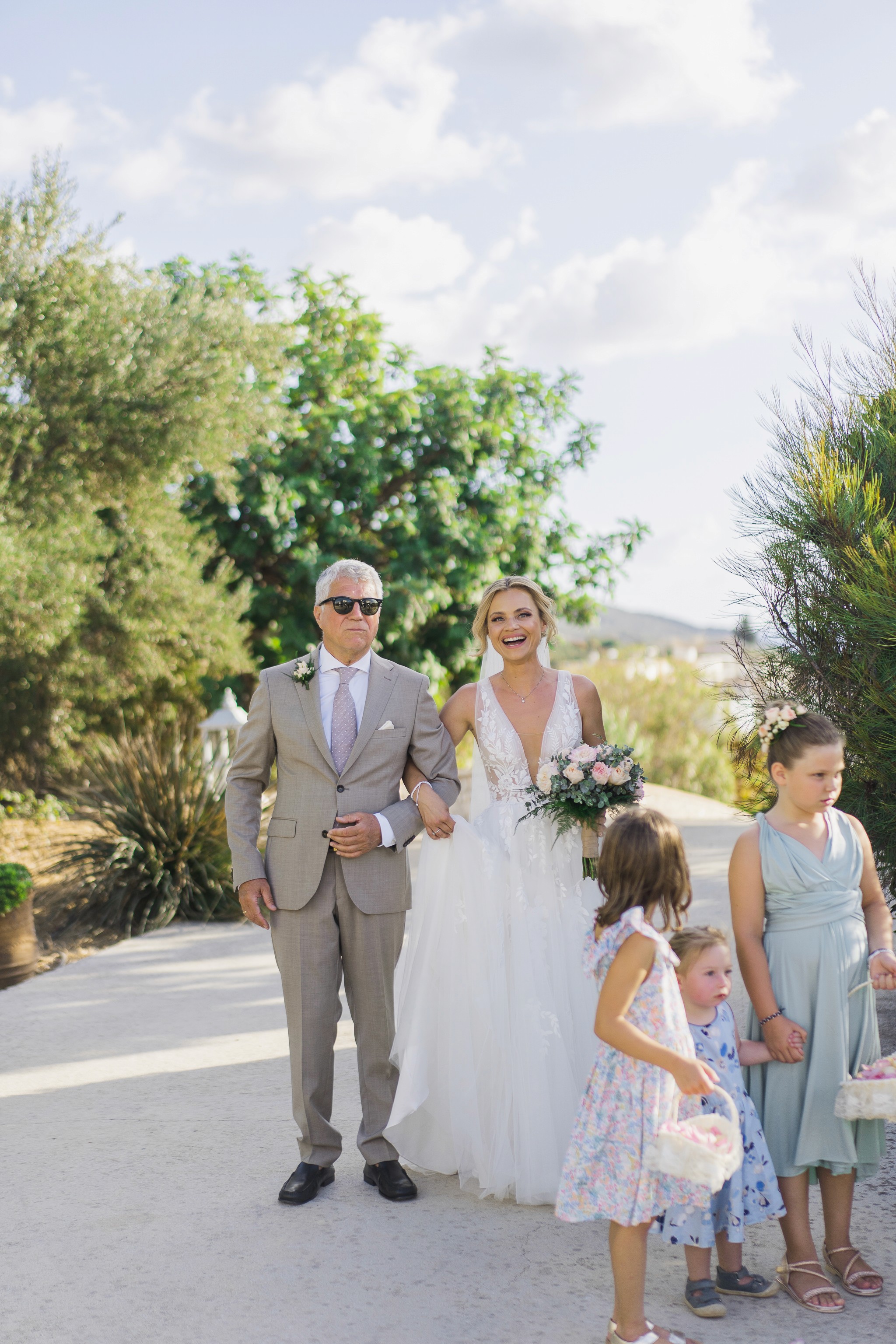 Bespoke wooden floral arch and rustic chairs for a luxury beach wedding ceremony in Greece