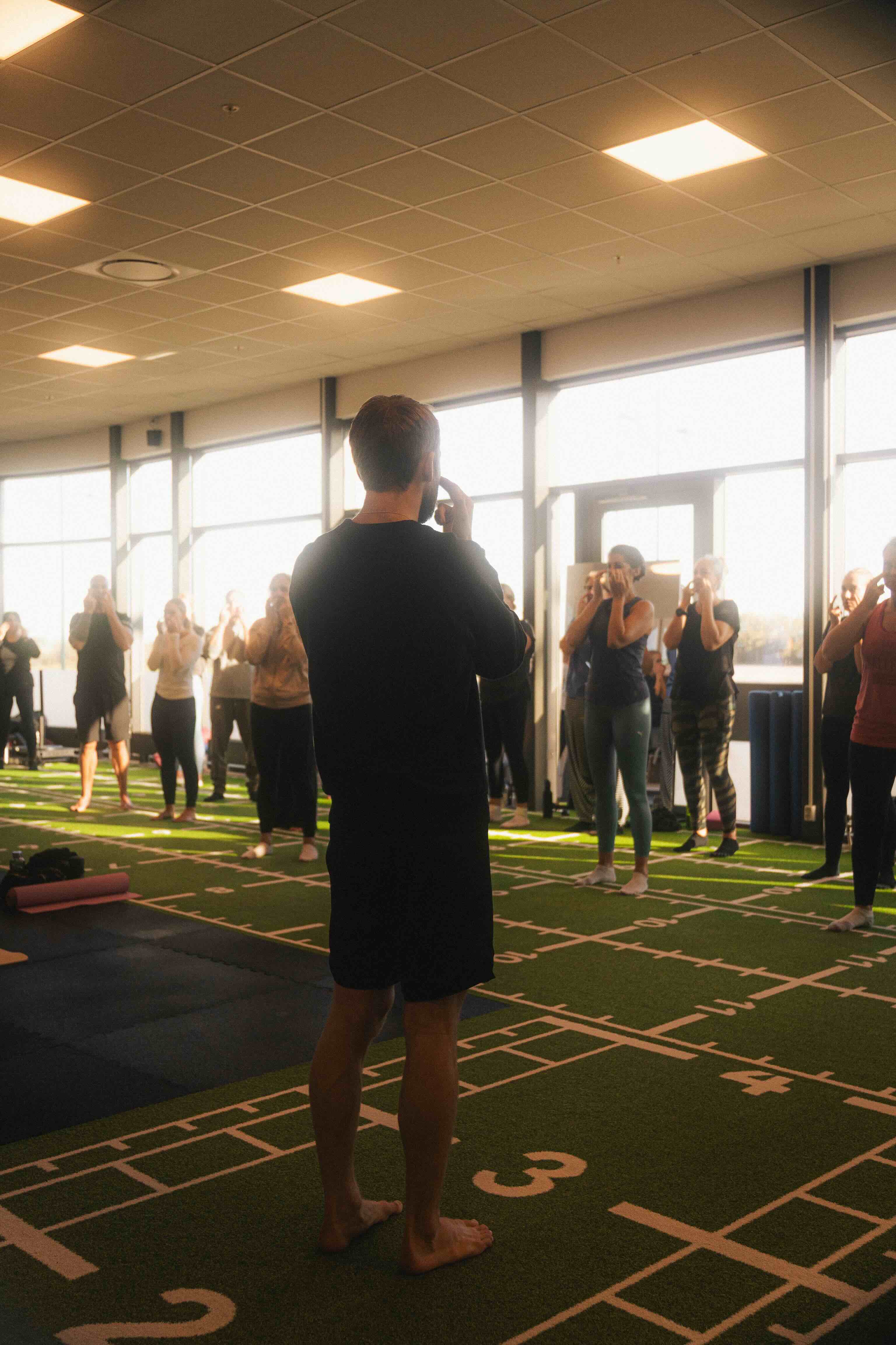 An older male basketball player with grey hair, wearing a blue jersey (number 29), running down the court during an indoor game.