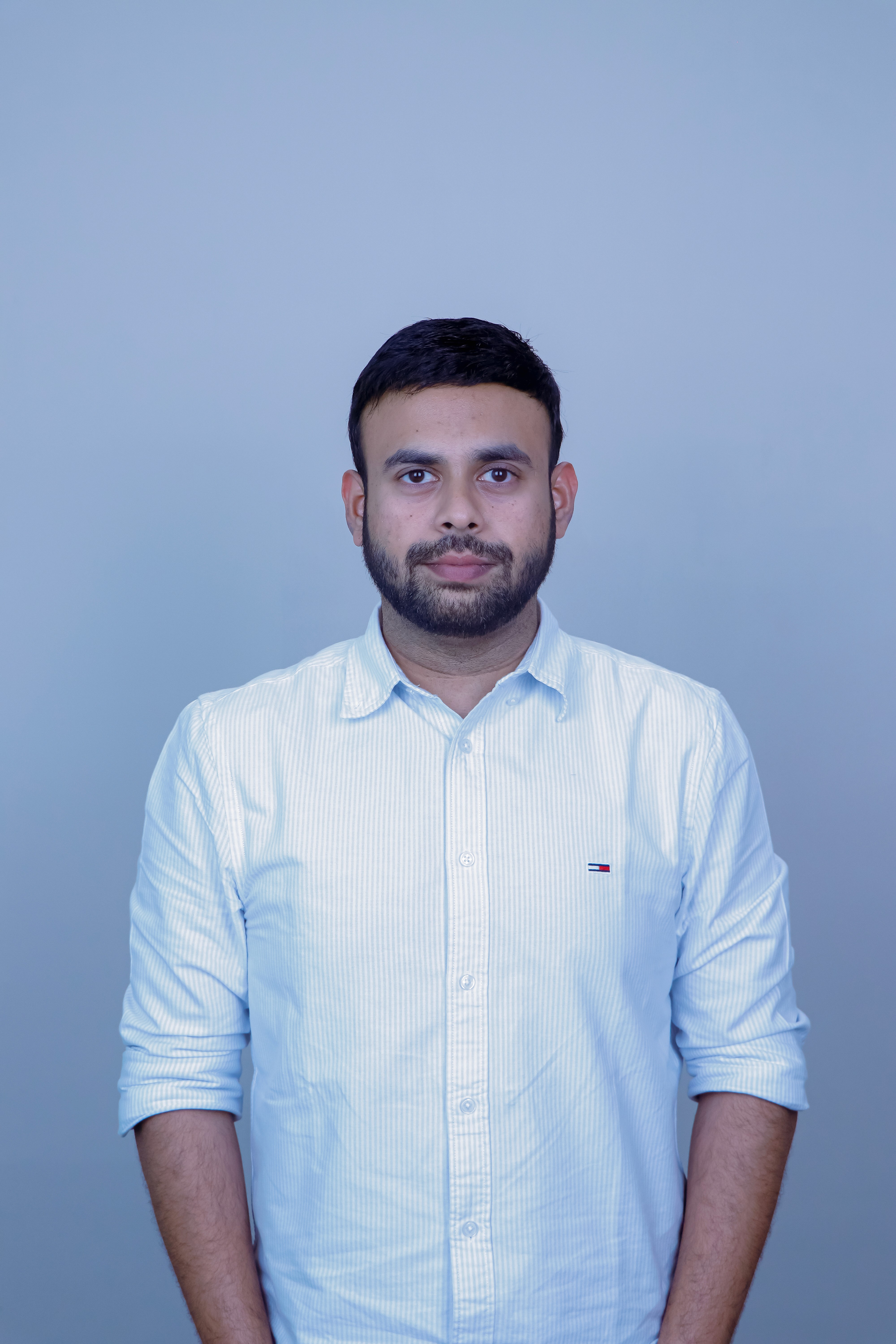 Man with arms crossed in modern office workspace.