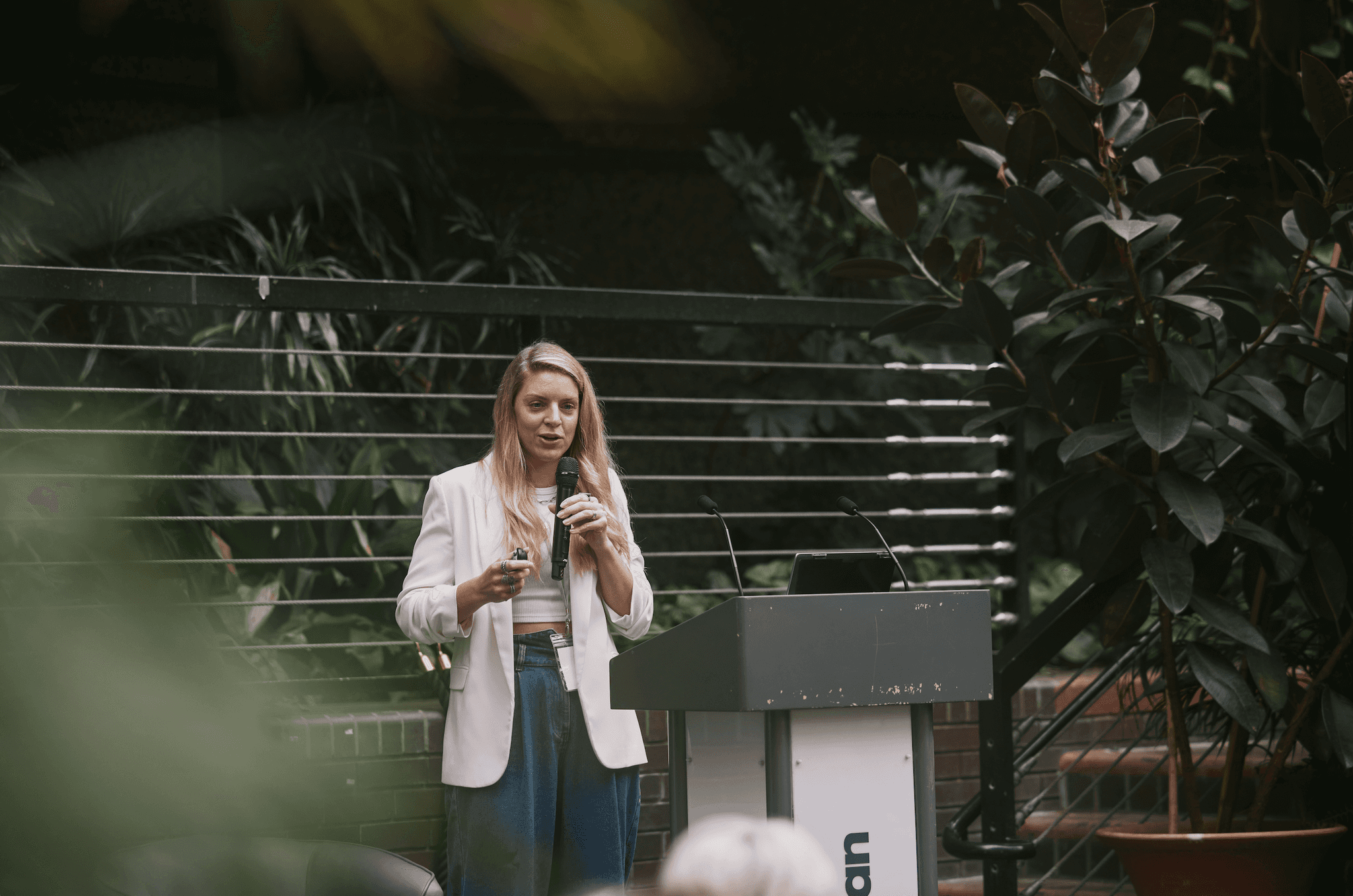 Image of Samantha standing at a podium giving a talk at Flux Convergence conference event, October 2024.