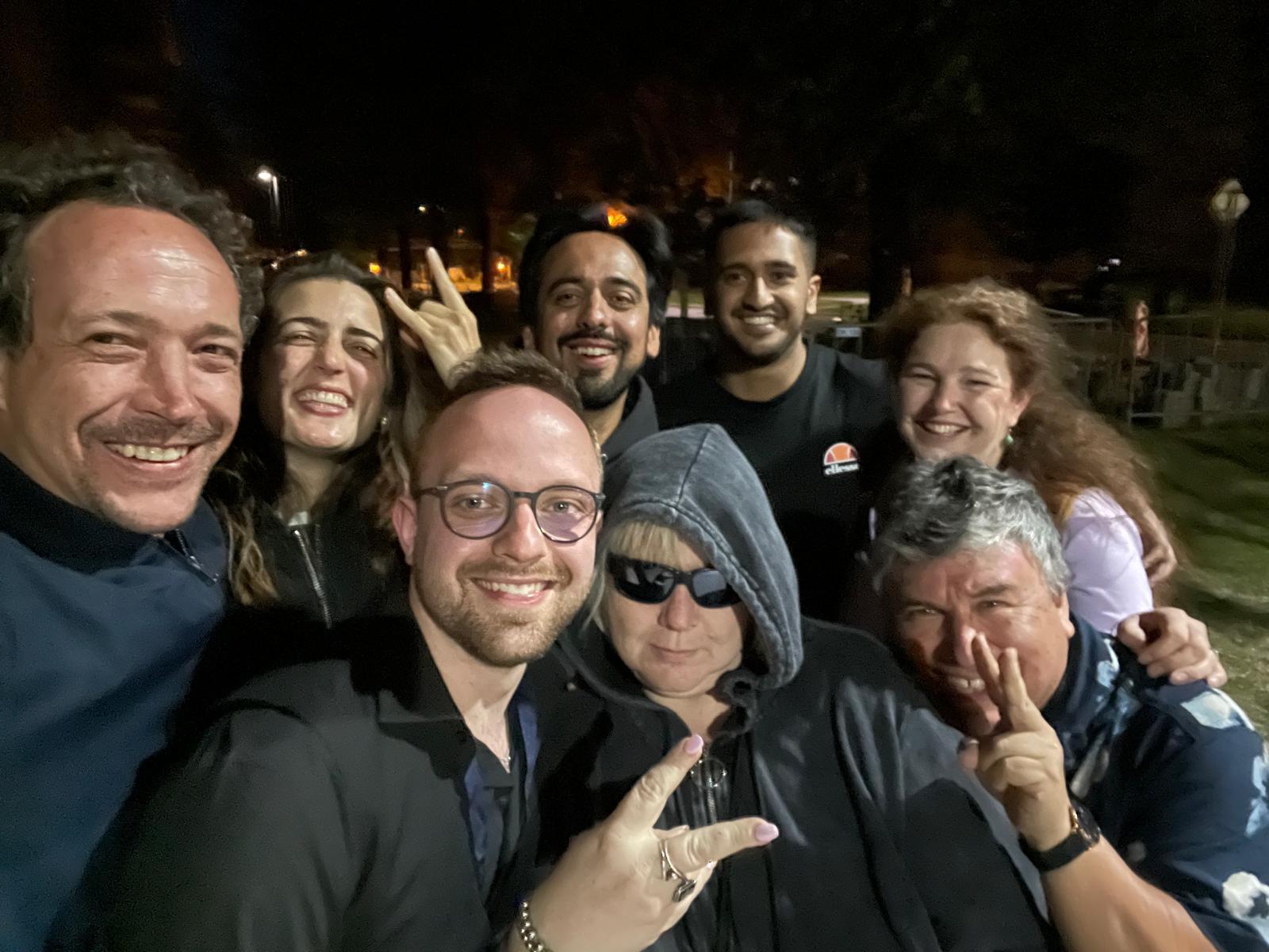 A group sharing an informal moment together outdoors at night.