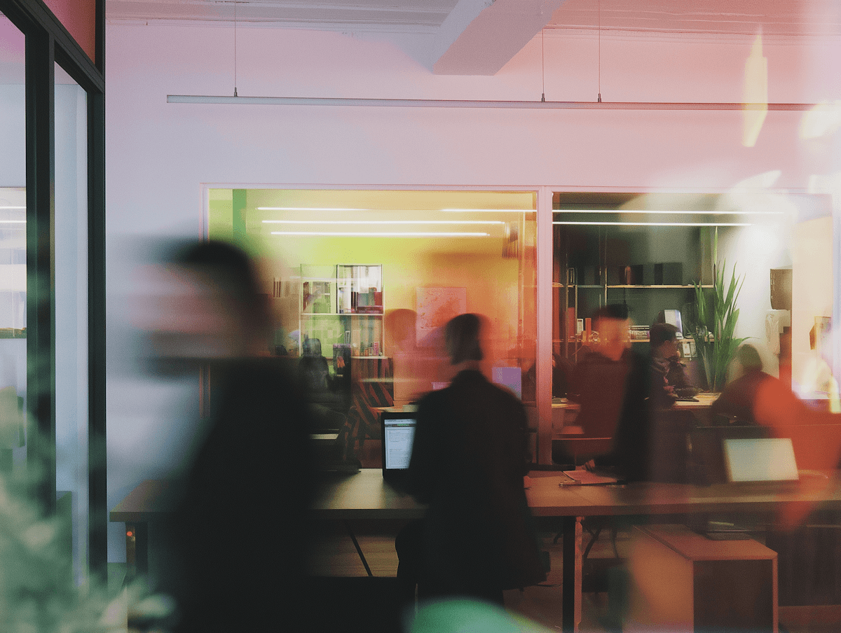 Abstract blurred motion of people working in a colorful office.