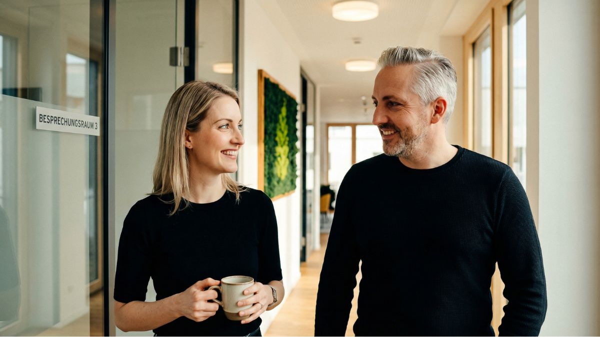 Führungskraft im offenen Gespräch mit einem Teammitglied im Flur