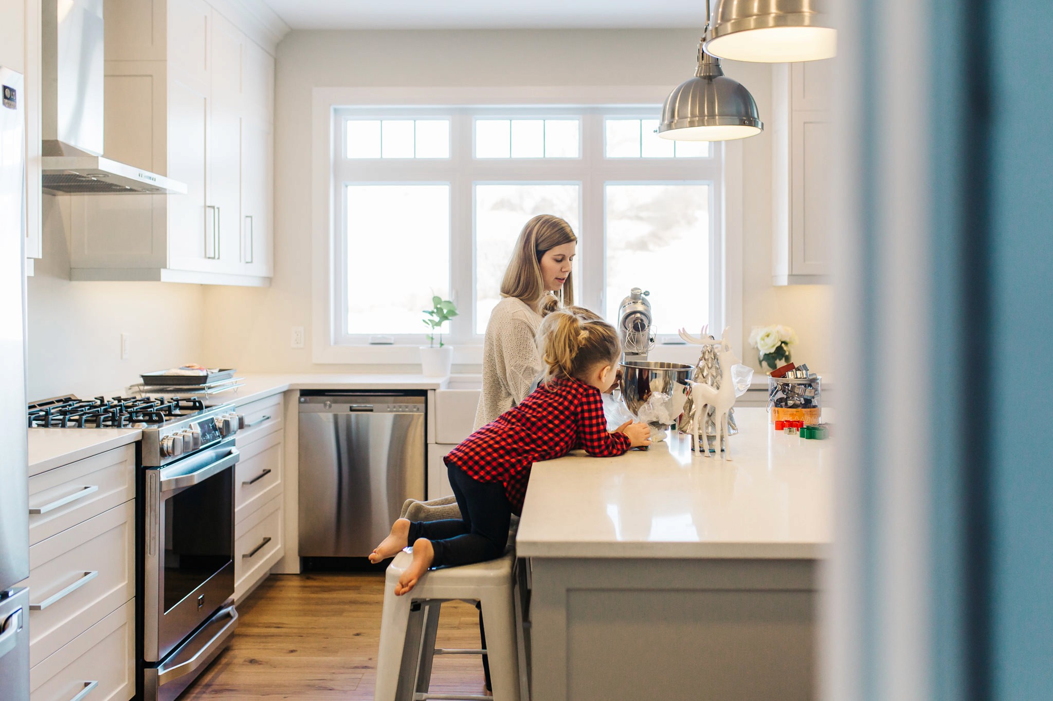View of the French countryside through a stone villa’s open living room, with sofas and trees framing the scene