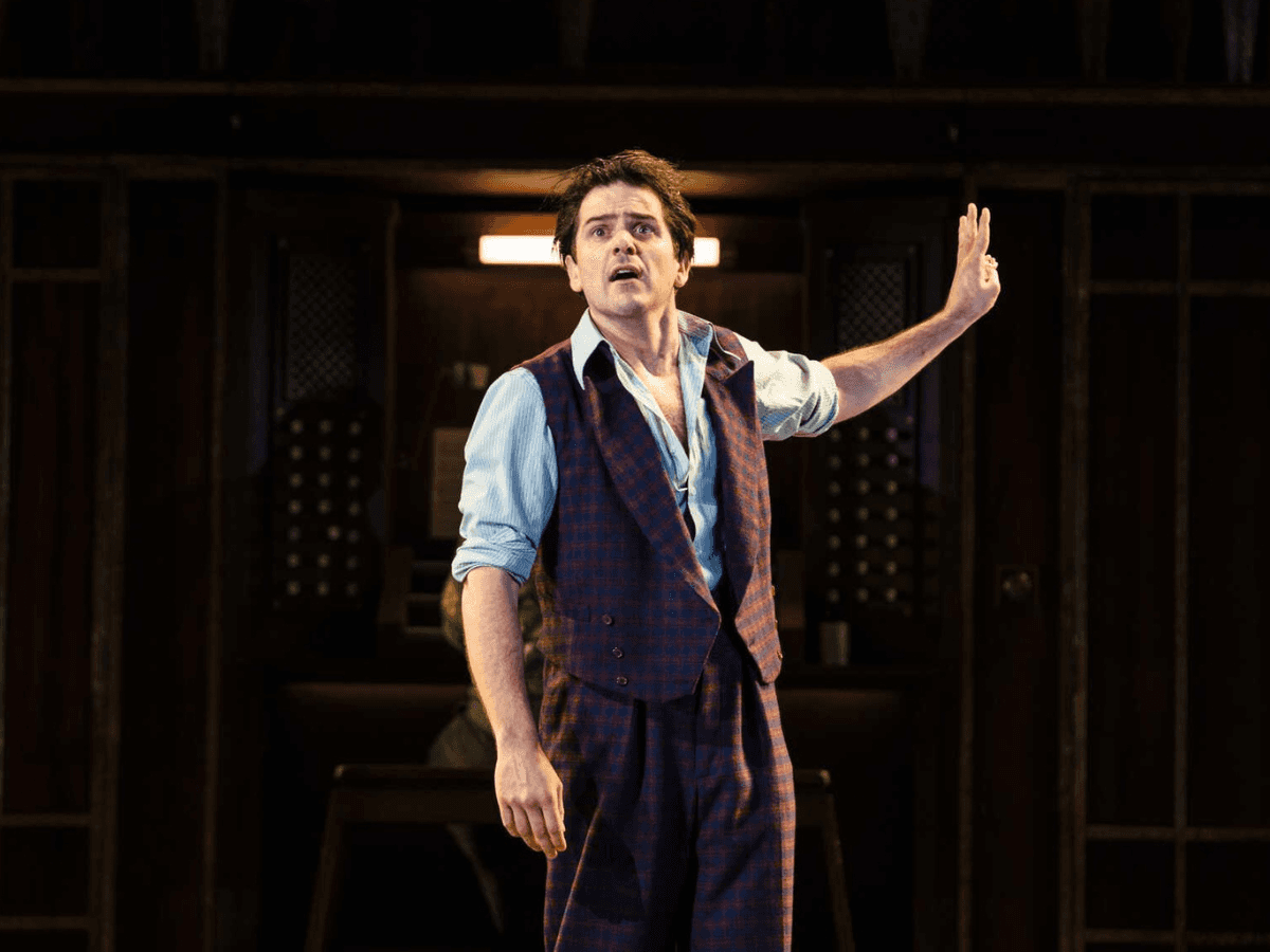 Man in a waistcoat gesturing mid speech in an intense scene from Twelfth Night.