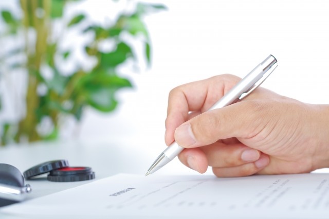 契約書にサインしている手元
