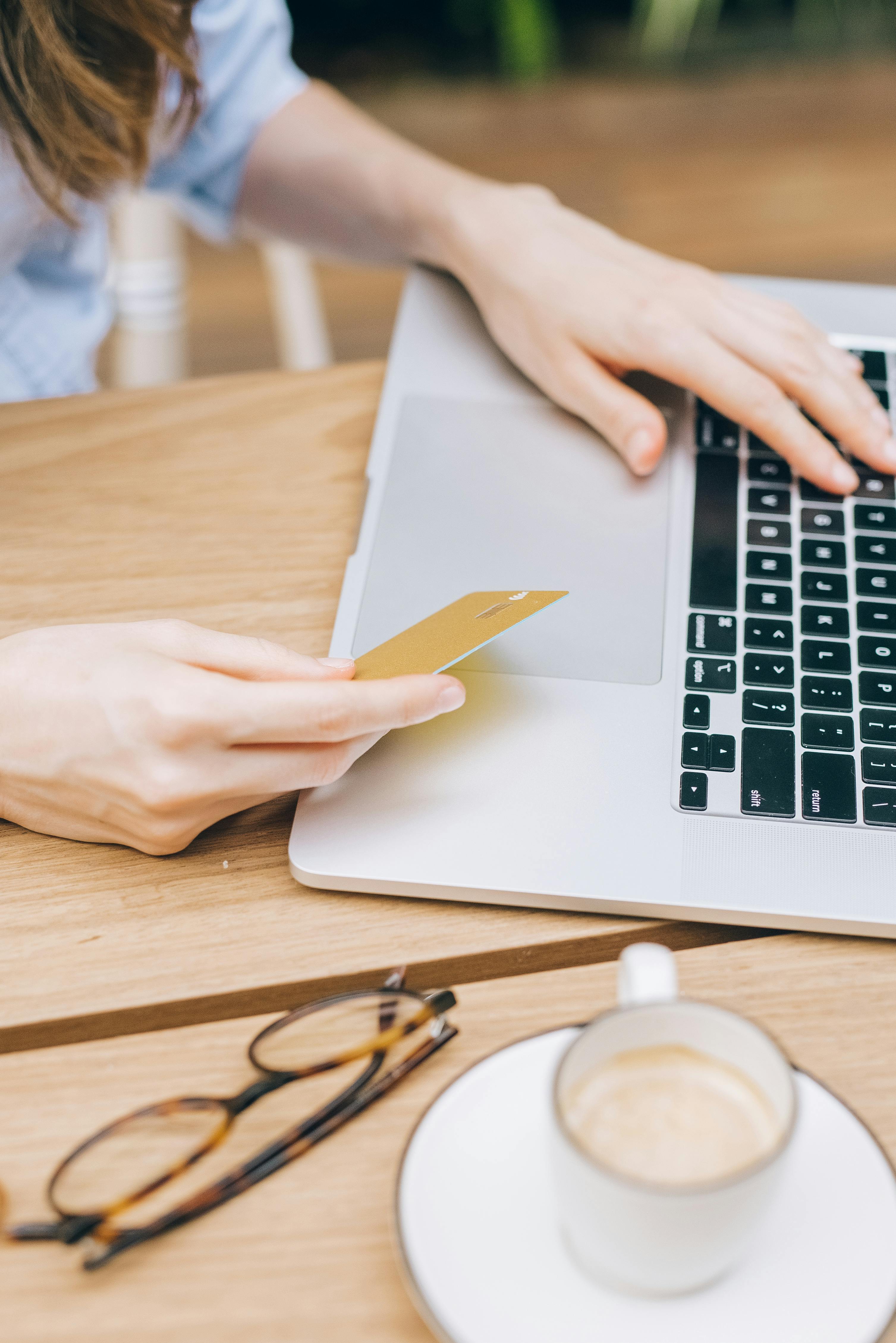 Woman holding a credit card while completing an online purchase on her laptop during checkout
