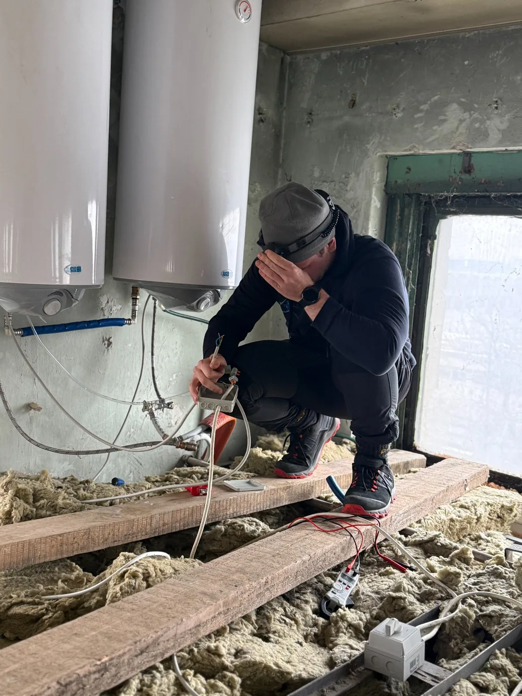 Ampermax villanyszerelő bojler elektromos bekötésén dolgozik padlástérben