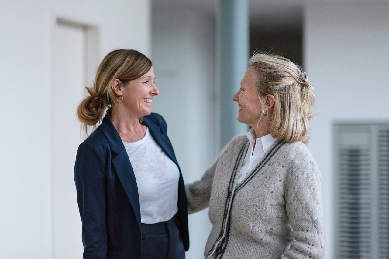 Friendly interaction between two women from Team, capturing the supportive and welcoming environment.