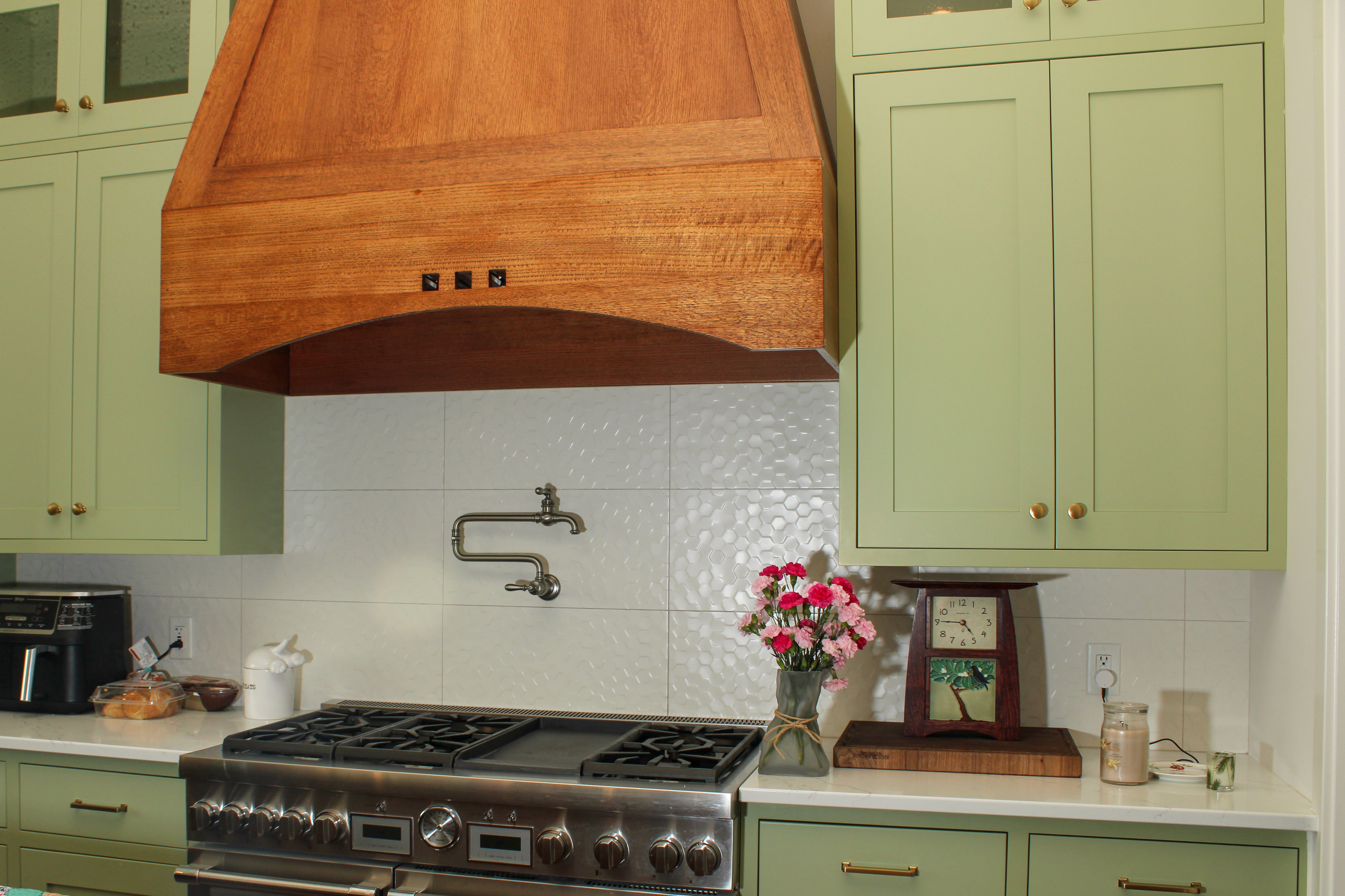 Retro-style kitchen in Southern Utah featuring green cabinets and wood hood above oven
