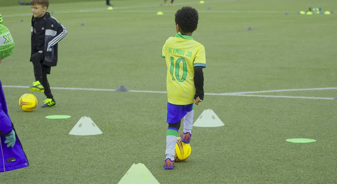 Kids dribbling football