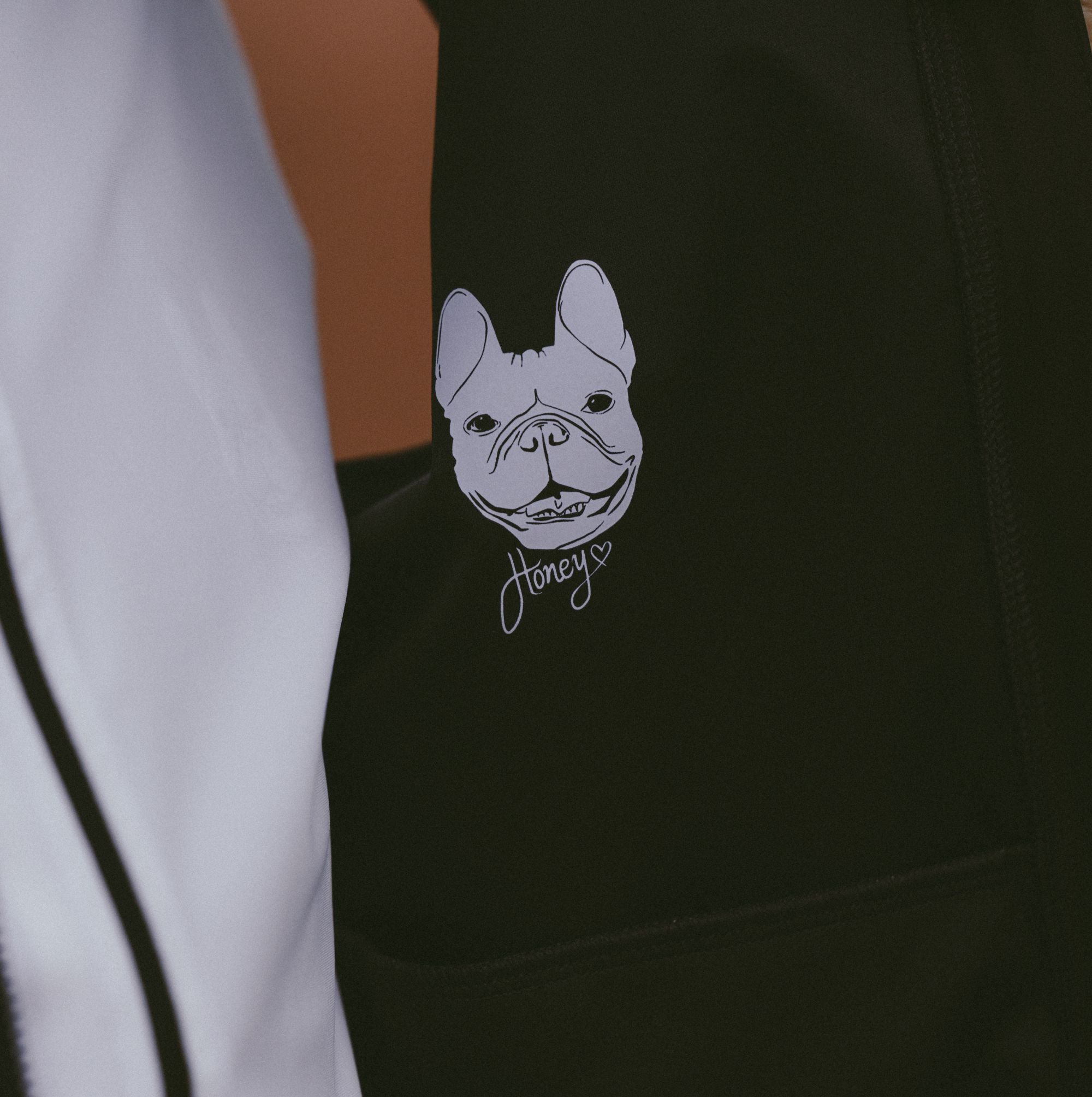 Close-up-detail-of-the-custom-graphic-design-on-the-black-garment-featuring-astylized-illustration-of-a-French-Bulldog-face-with-the-script-name-Honey-written-below-it