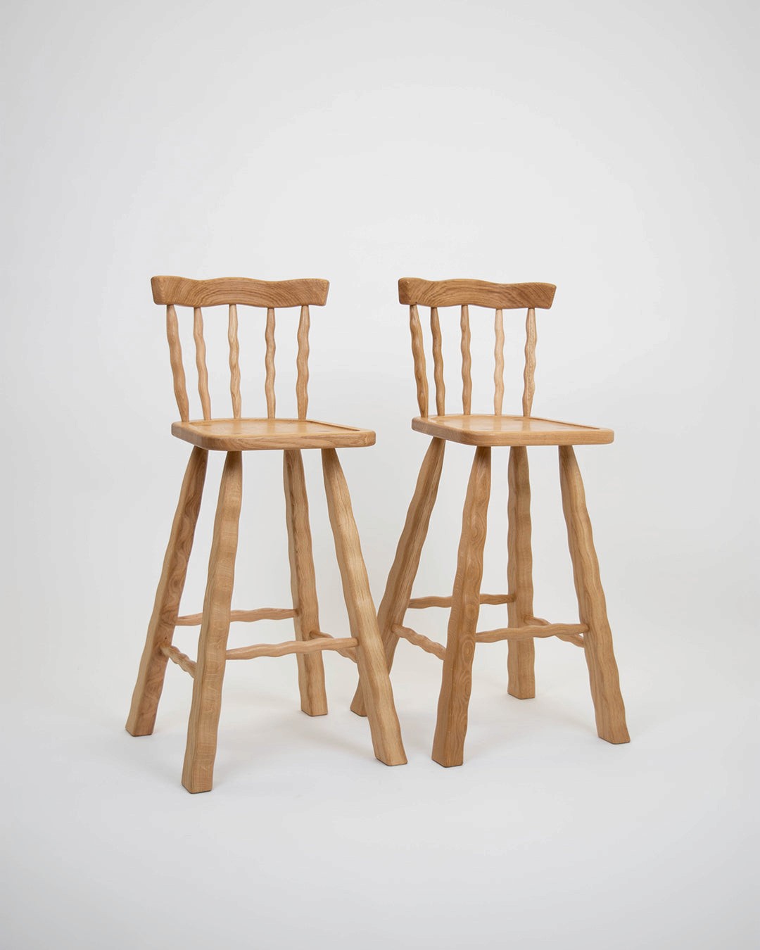 Two Oak bar stools on a white background