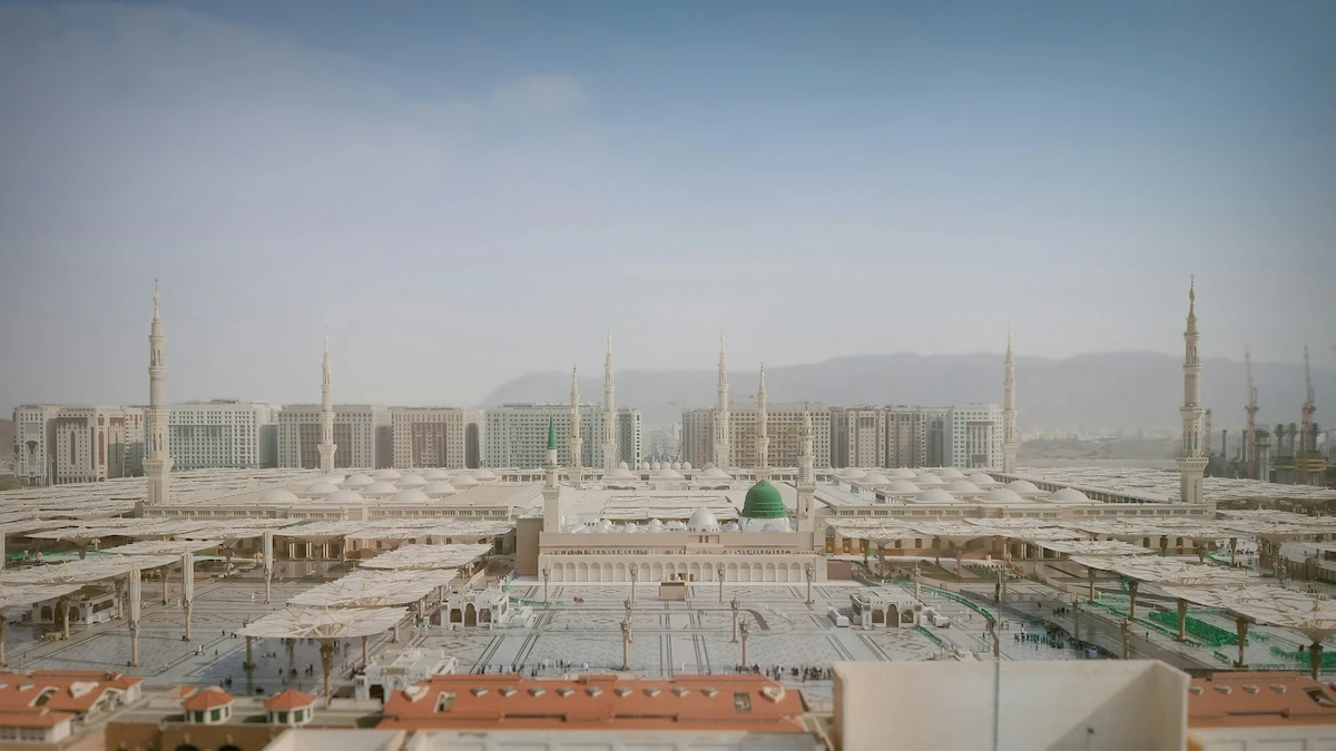 Panoramic view of Al-Masjid an-Nabawi in Medina with the green dome and courtyard umbrellas.