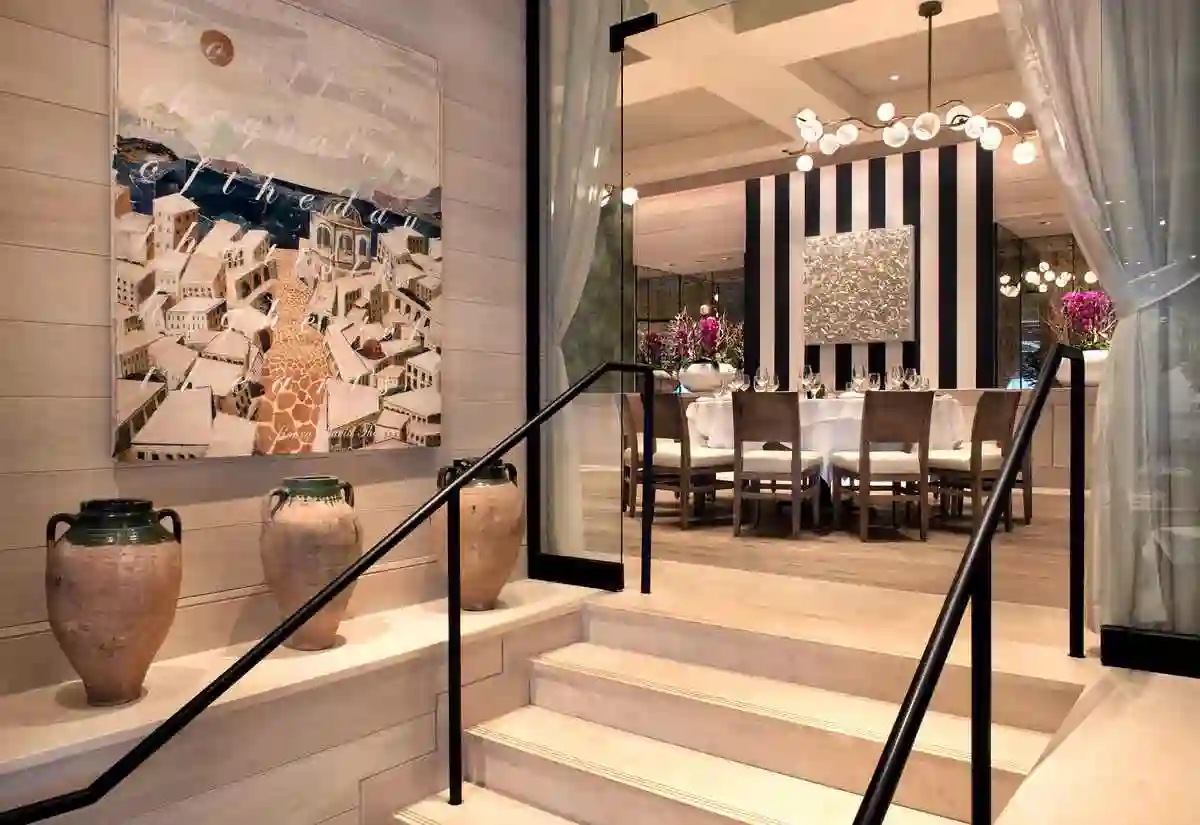 Modern lobby interior with stylish seating, decorative art, and a welcoming atmosphere, featuring stairs leading up.