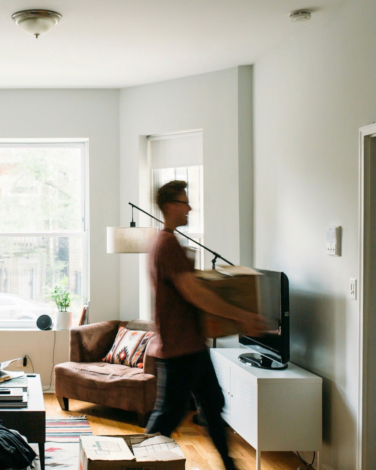 A person with a moving box in a bright, clean home