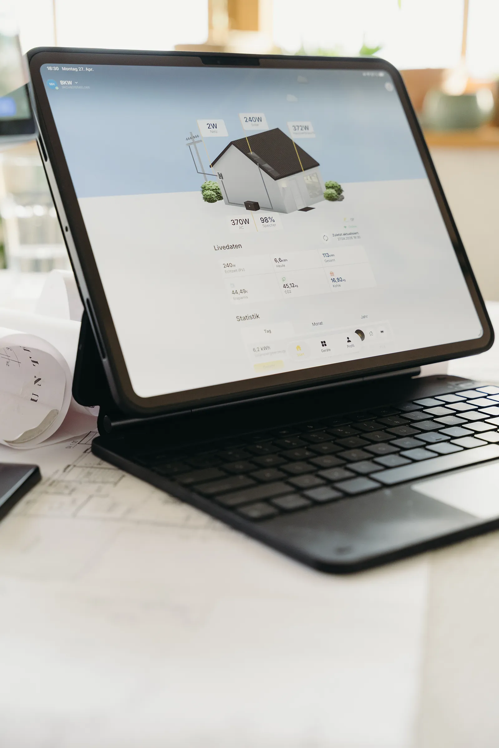 Digitale Auswertung von Photovoltaik-Erträgen und Energieflüssen eines Wohngebäudes auf einem Tablet.