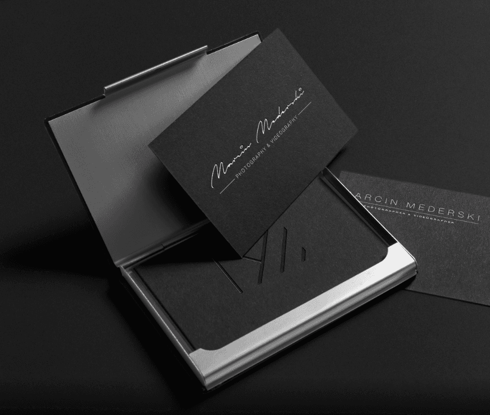 man wearing grey t-shirt standing in front of man sitting on chair