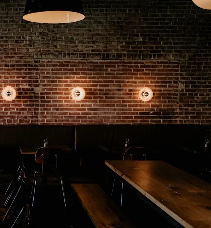 The long view across the dining room, exposed brick under low pendants