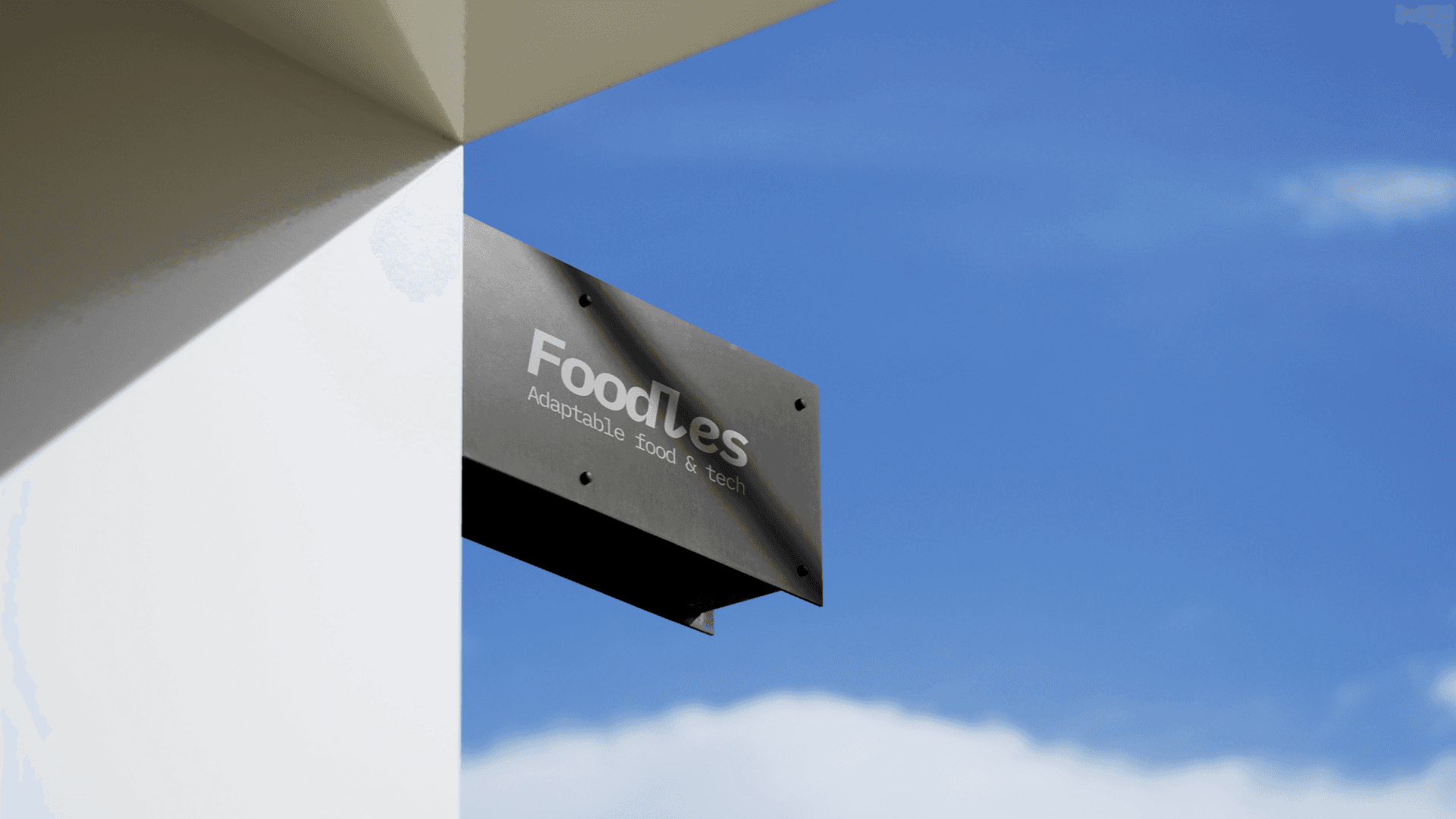 Un panneau extérieur minimaliste affichant le logo de Foodles et le slogan "Adaptable food & tech". Ce visuel suggère une approche moderne et épurée, associée à la technologie et à l'agilité, positionnant l'entreprise comme un acteur du secteur innovant et flexible.
