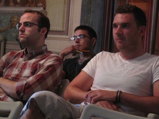A group of people listening to a lecture and taking notes.
