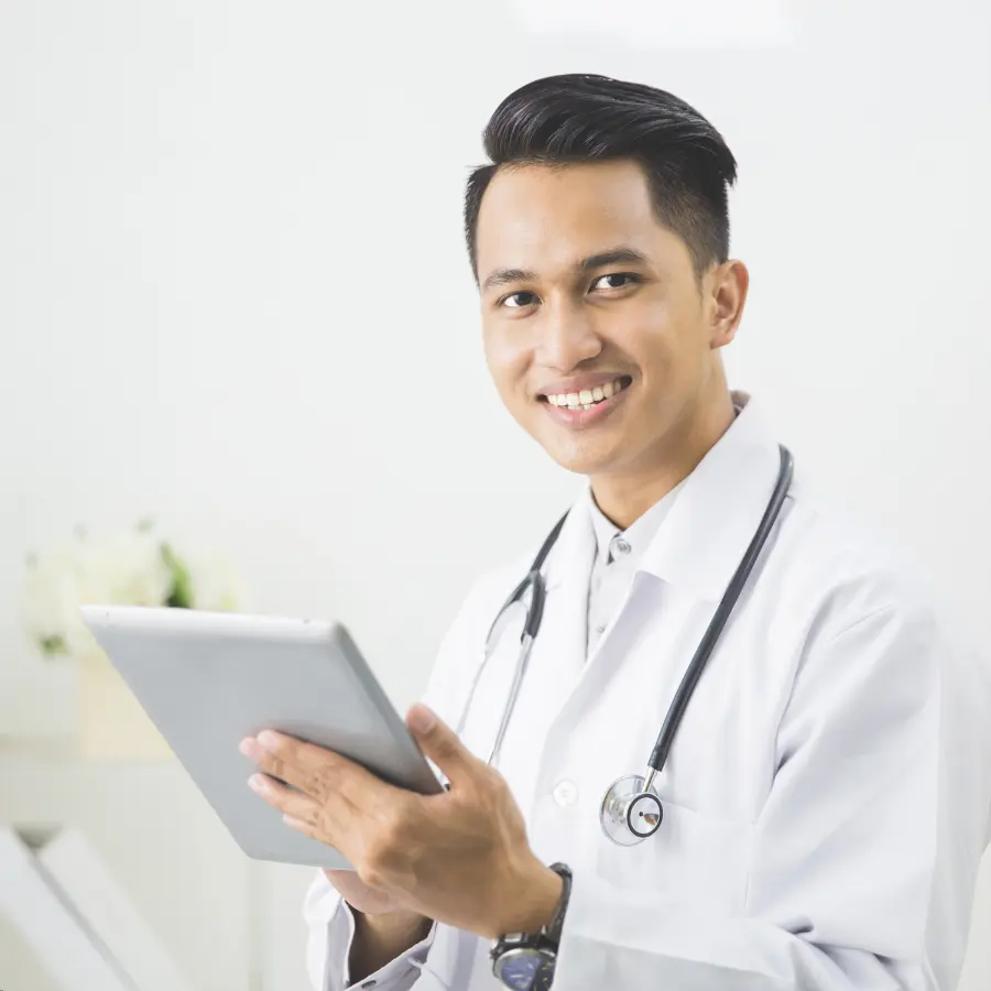 Healthcare scribe technology assisting a smiling doctor using a tablet for digital medical documentation