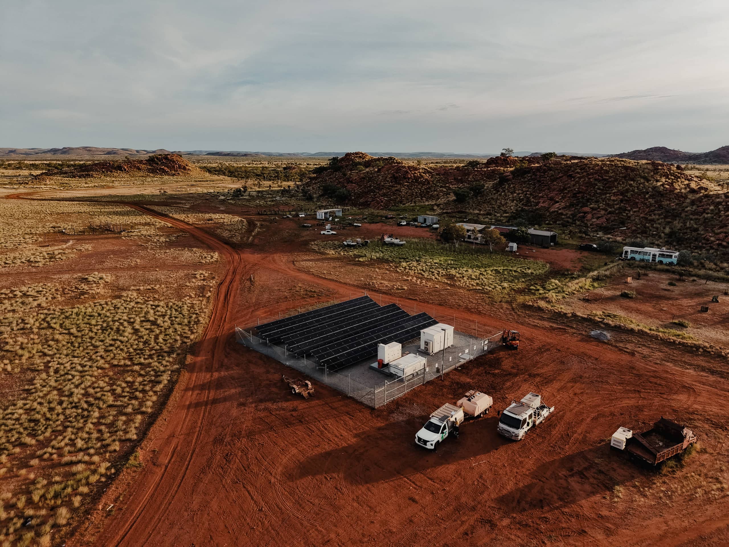 Drone view of a remote solar power installation in the Australian outback with service vehicles and equipment.