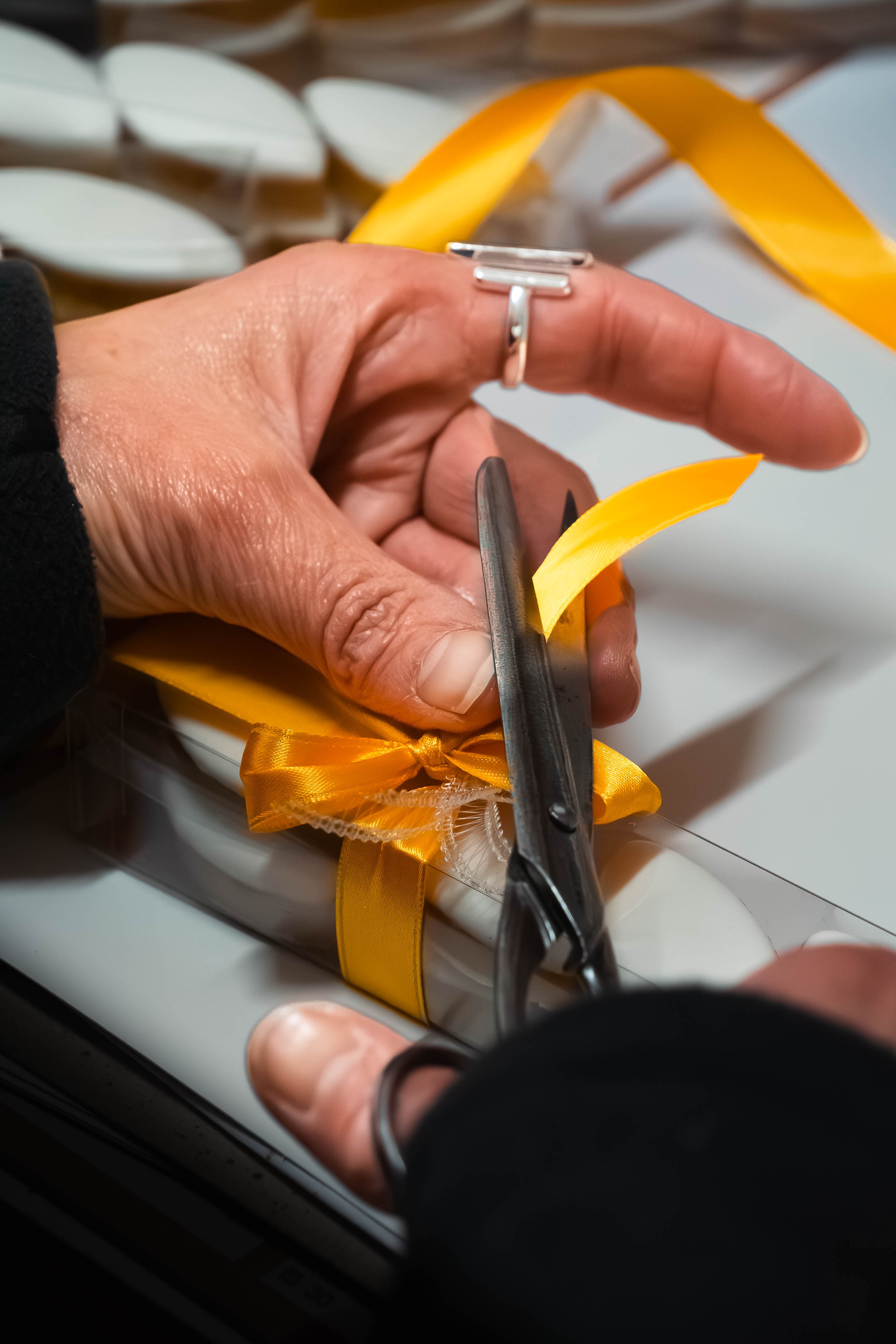 Zoom sur les mains lors de la préparation de boîtes de dattes. Préparation et coupe du ruban.