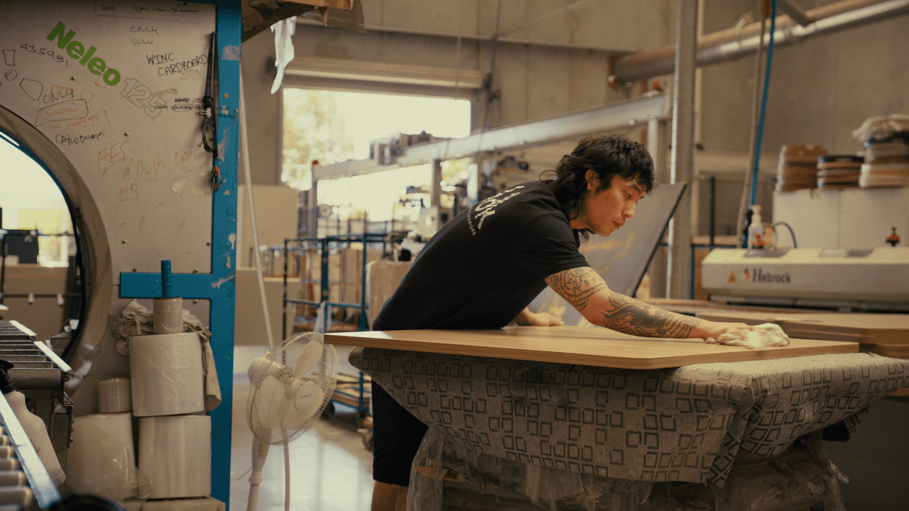Person working on polishing a large piece of wood