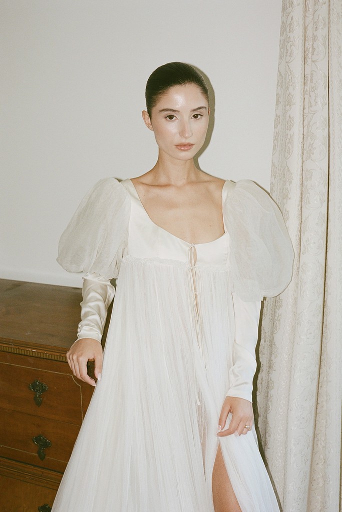 Bride in a soft white wedding dress with puff sleeves, photographed indoors with flash