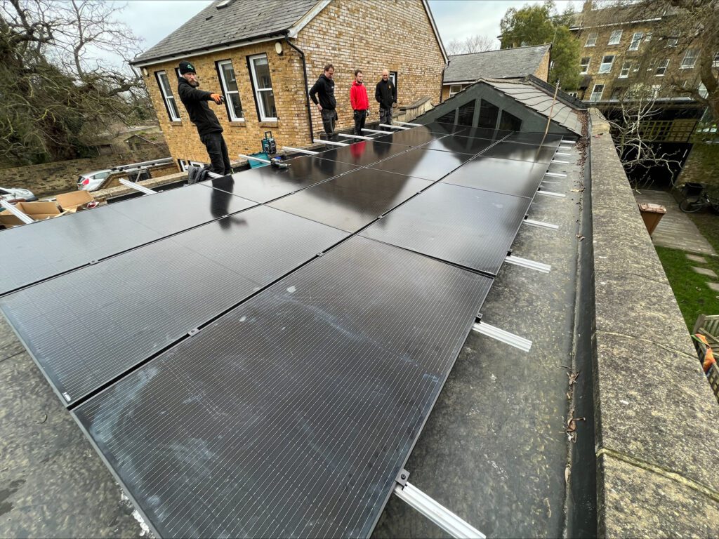 Installers laying solar panels on the low-pitched roof at Ital Cutlery