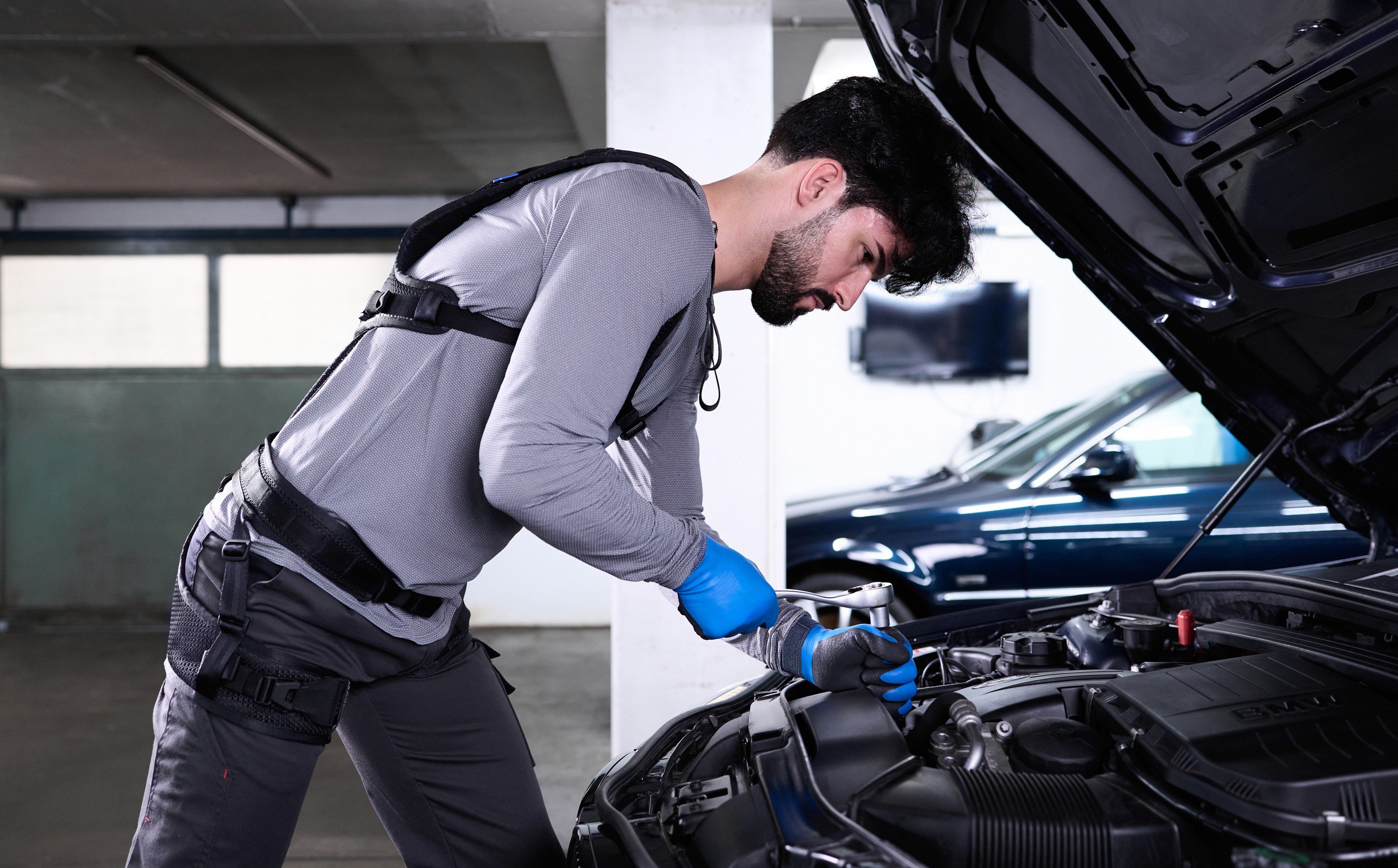 Mécaniciens portant un exosquelette Auxivo Liftsuit en travaillant afin de réduire les blessures aux dos