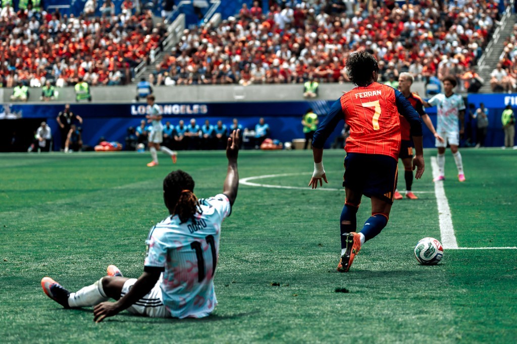 Spain's Ferran Torres dribbles past a fallen Jérémy Doku of Belgium during their World Cup quarterfinal in Los Angeles