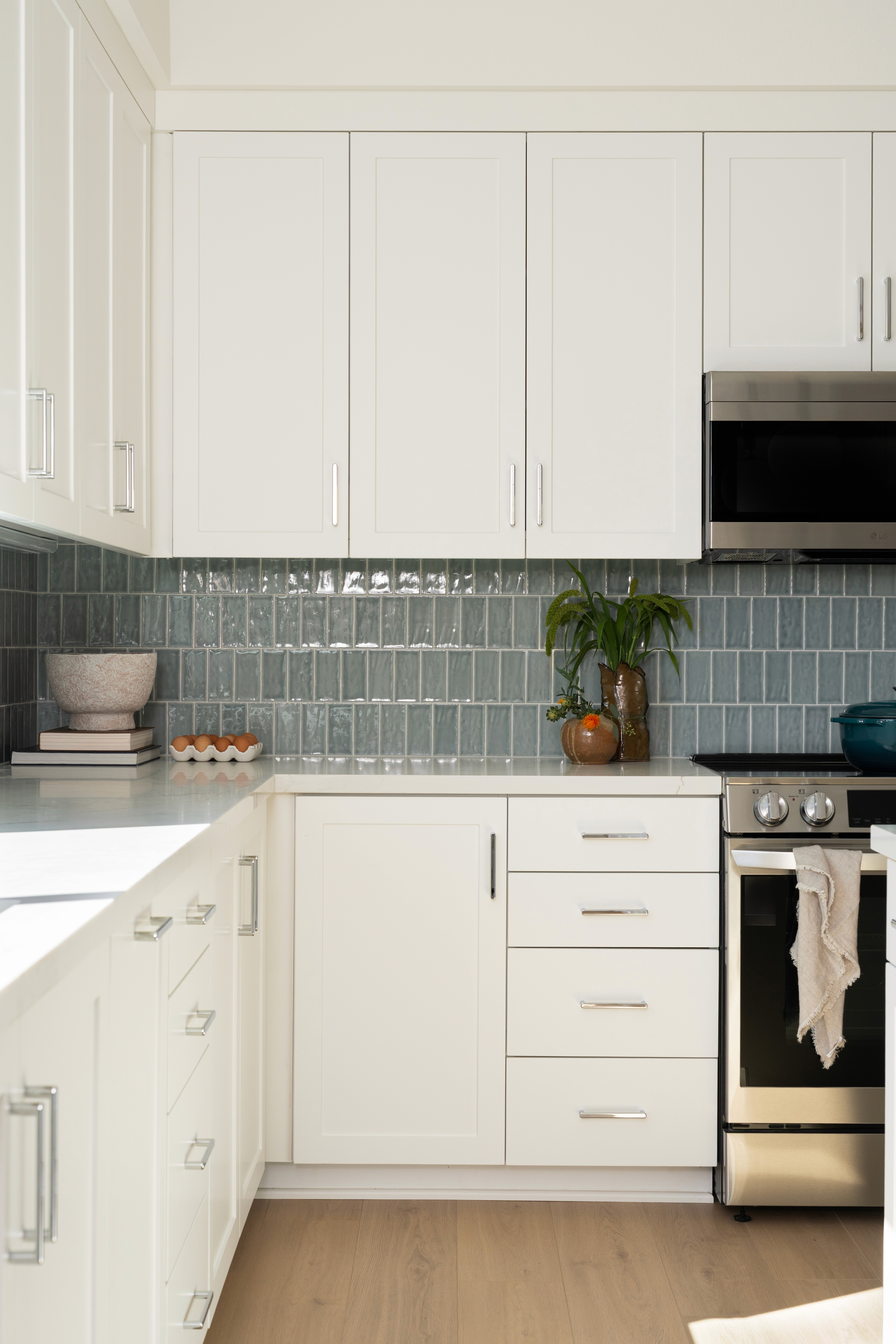Kitchen cabinets, counter and appliances with decor