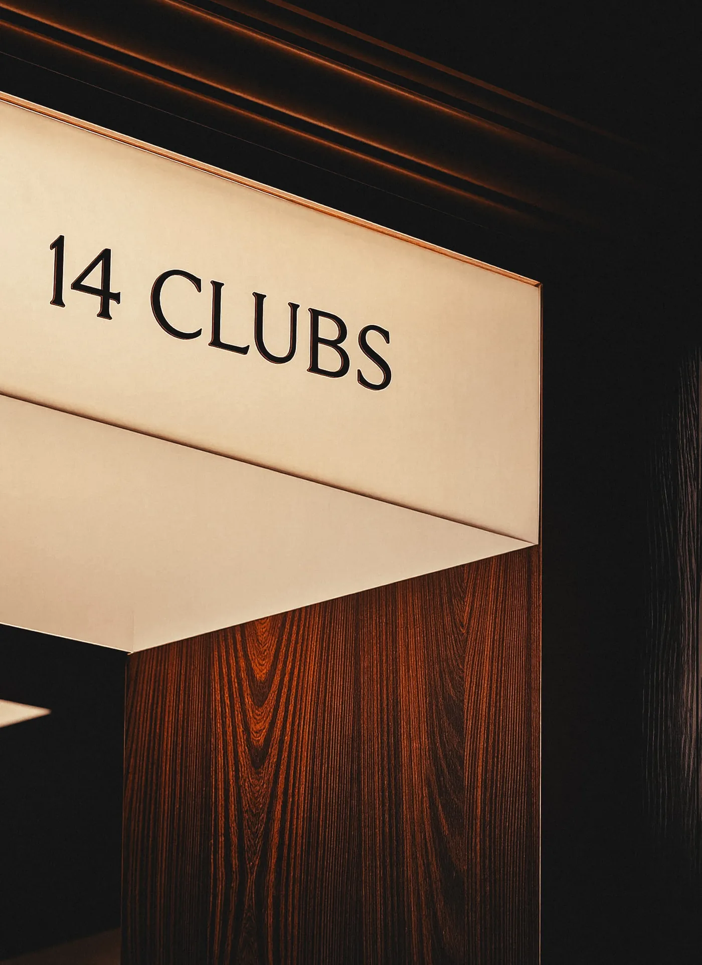 Illuminated 14 Clubs sign set into timber panelling at the club entrance