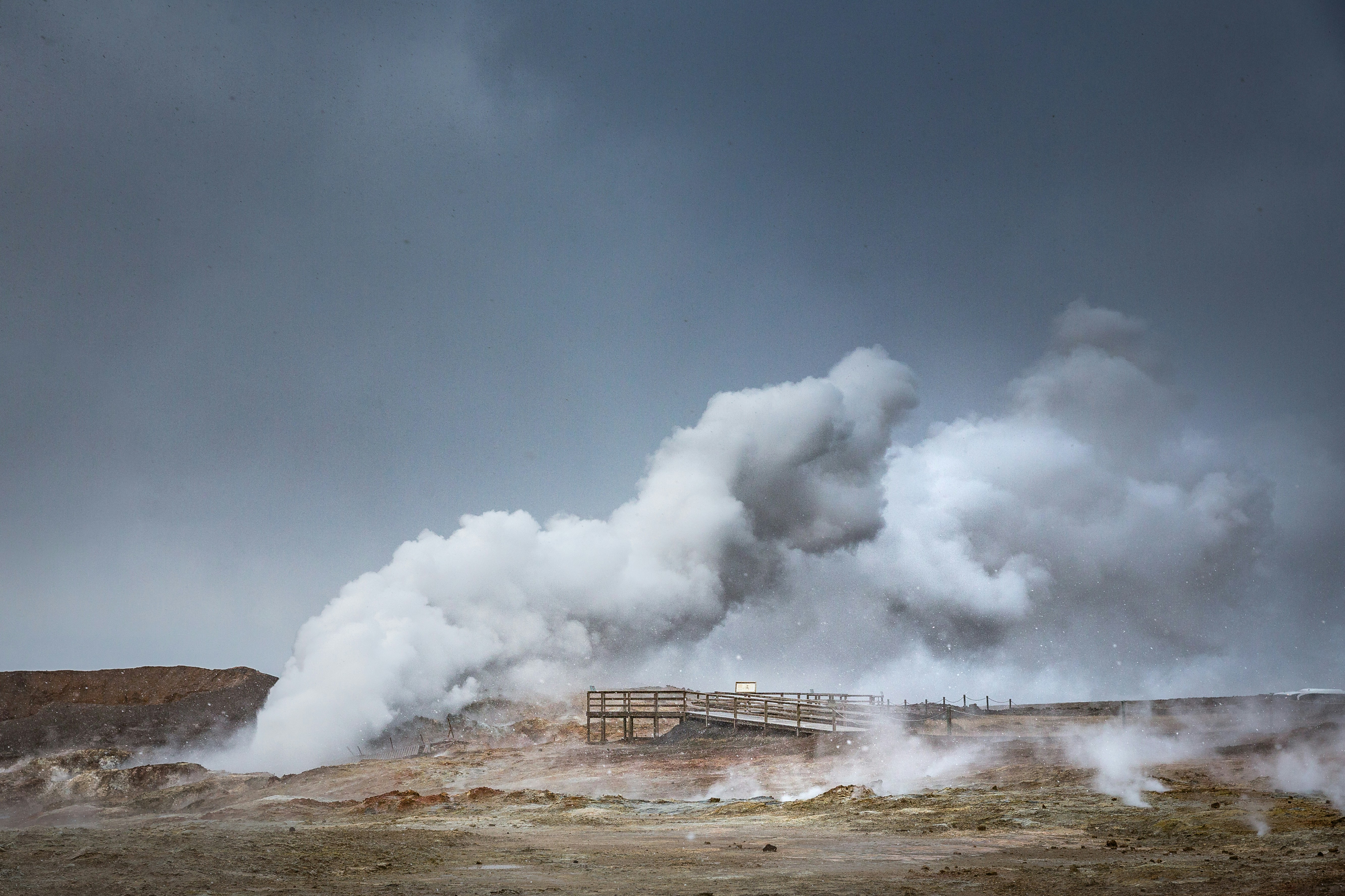 Hot steam rising from mud pools at Gunnuhver geothermal area in Iceland.