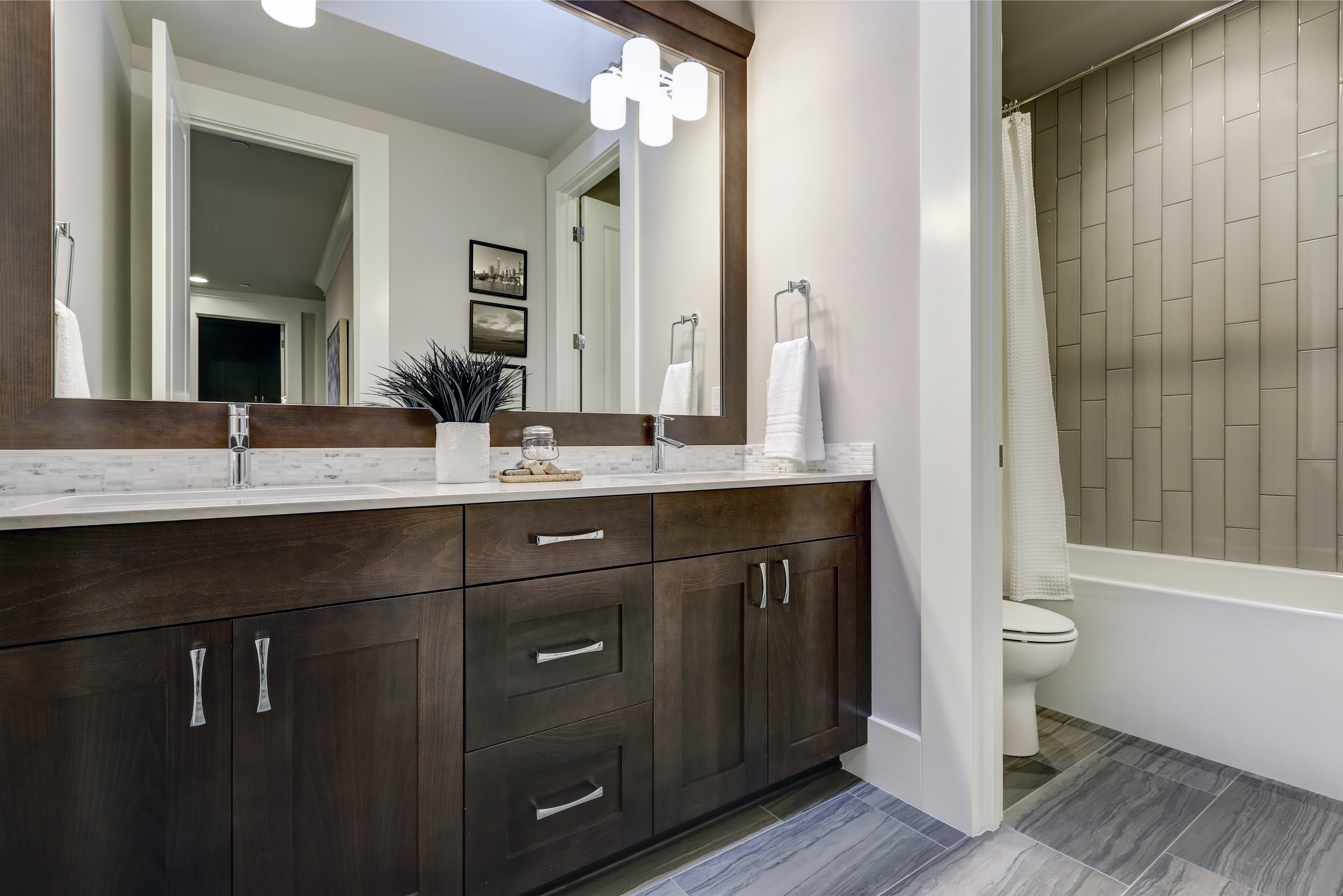 white ceramic bathtub near brown wooden cabinet