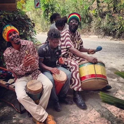A man playing a drum in front of a group of people