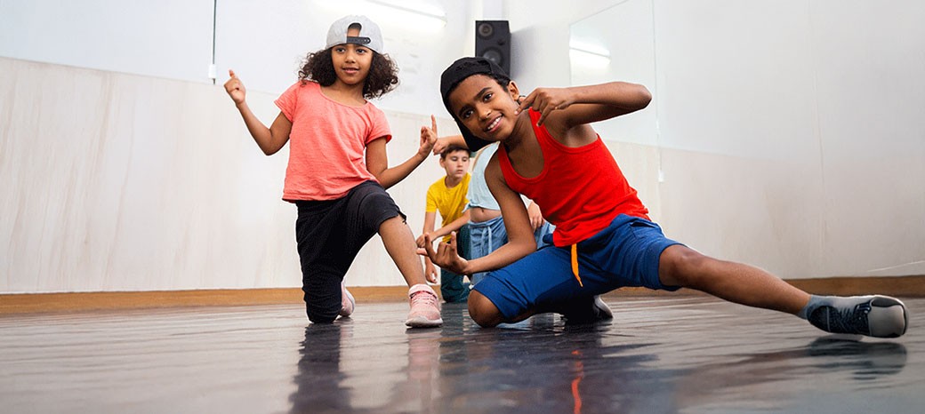 Students practicing breakdance footwork and power moves in high-energy after school dance program