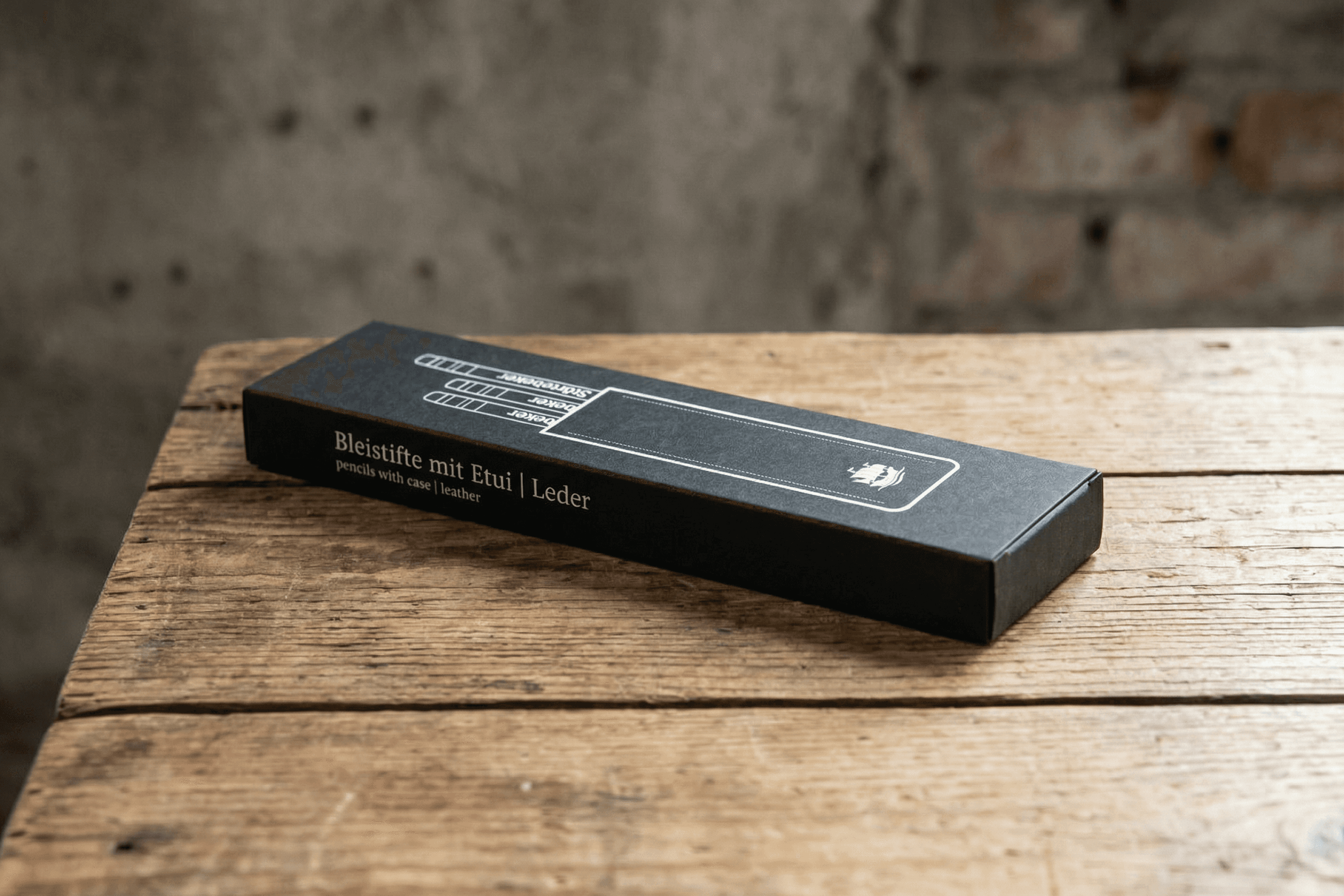 Black box with pencils, case, and leather text