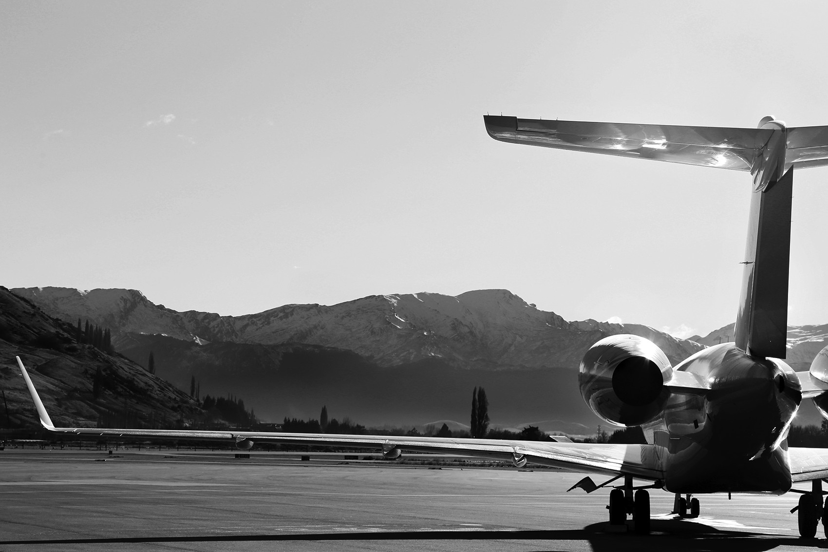 Close-up of a private jet wing against a cloudy sky