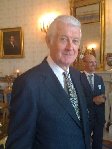 portrait of an older man in a black suit, a white shirt and a tie